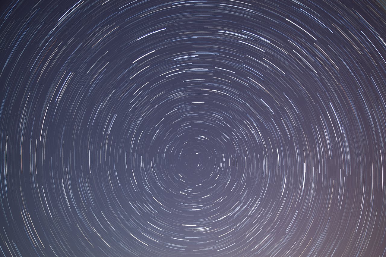 Long exposure shot of star trails creating circular patterns in the night sky.